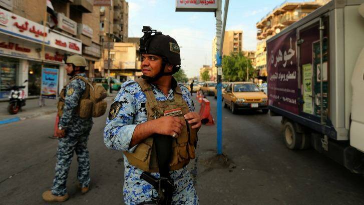Nervous state: on a day when six bombs went off in the city, Iraqi policemen patrol Baghdad's Karrada district.  Photo: Kate Geraghty