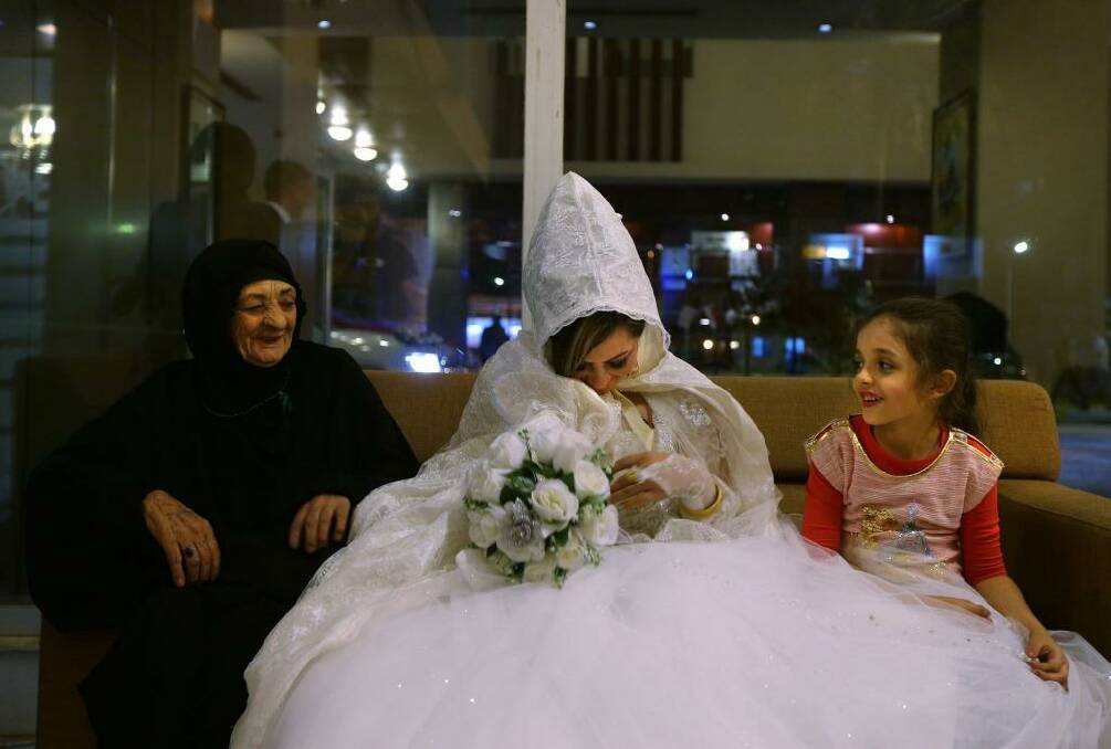 Rasha Kareem (centre) with her new mother-in-law and her niece at the Baghdad Hotel in the city's Saadoun district. There were 22 weddings at the hotel on Thursday night. Photo: Kate Geraghty