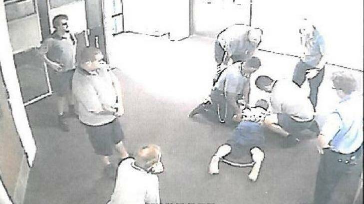 CCTV images appear to show a teenager with ankle-cuffs being held down at the Townsville centre. Photo: Supplied