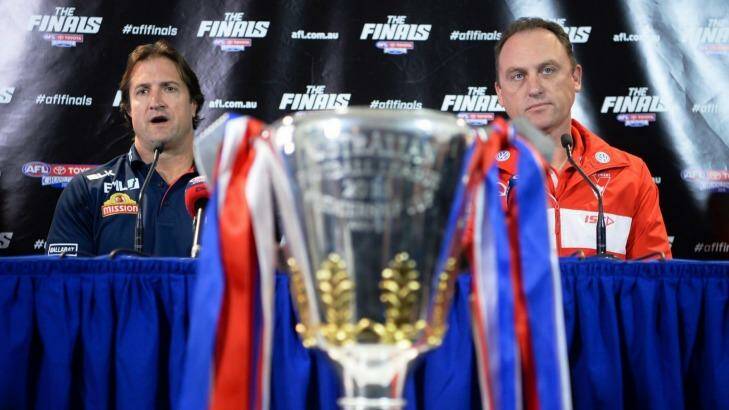 Coaches Luke Beveridge and John Longmire do their best to ignore the object of the ambitions - the AFL cup. Photo: Justin McManus