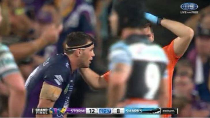 Not removed from field: Dale Finucane is attended to by a Storm trainer during the 2016 grand final against Cronulla Sharks but was allowed to play on. Photo: Channel Nine