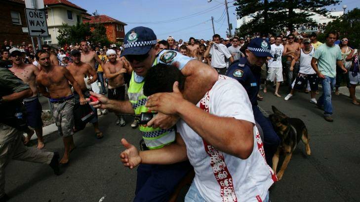 Terrible scenes: A police officer shields a man during the infamous Cronulla riots of 2005. Photo: Nick Moir