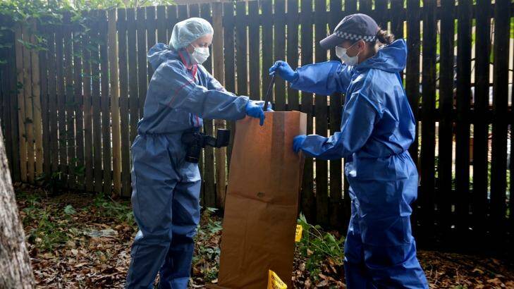 Police collect metal bar from the park next to the home where eight children were killed. Photo: Edwina Pickles