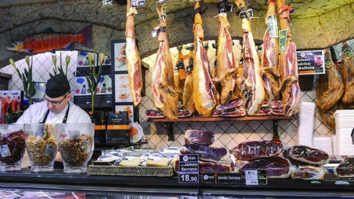 Serrano and Iberian Ham for sale at La Boqueria Food Market, Barcelona,Spain.   Photo: iStock