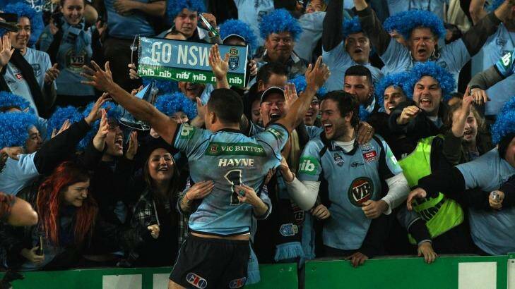 Singing, the Blues: Jarryd Hayne celebrates with Blues fans after NSW won back the origin trophy at ANZ Stadium. Photo: Wolter Peeters