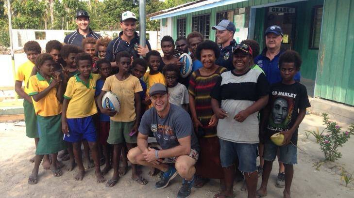 Helping the locals: Brian Norrie, Daniel Holdsworth, Adam Peek, Corey Hughes and Steve Pike (top left)  in the New Ireland province of Papua New Guinea. Photo: Supplied