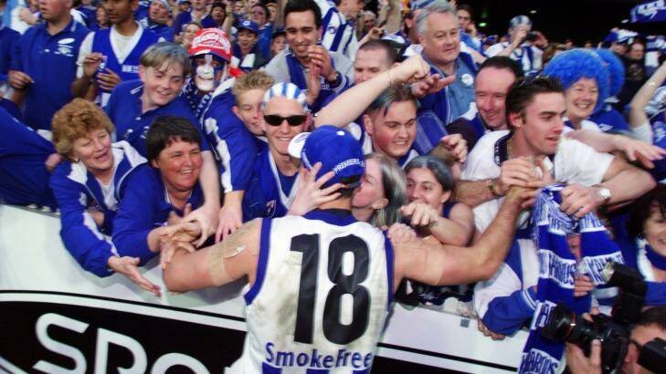 Kangaroos captain Wayne Carey celebrates the premiership with fans in 1999. Photo: Vince Caligiuri