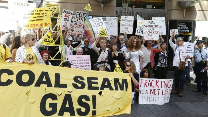 Protesters wave placards outside AGL's Sydney headquarters during a demonstration in 2014. Photo: Peter Rae