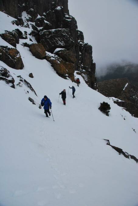 Walkers go Indian file along the side of Cradle Mountain. Photo: John Braid