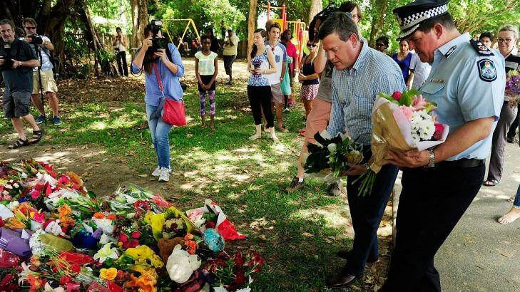 Acting Premier Tim Nicholls lays down flowers at the makeshift memorial to eight children who died in a Cairns home. Photo: Ian Hitchcock