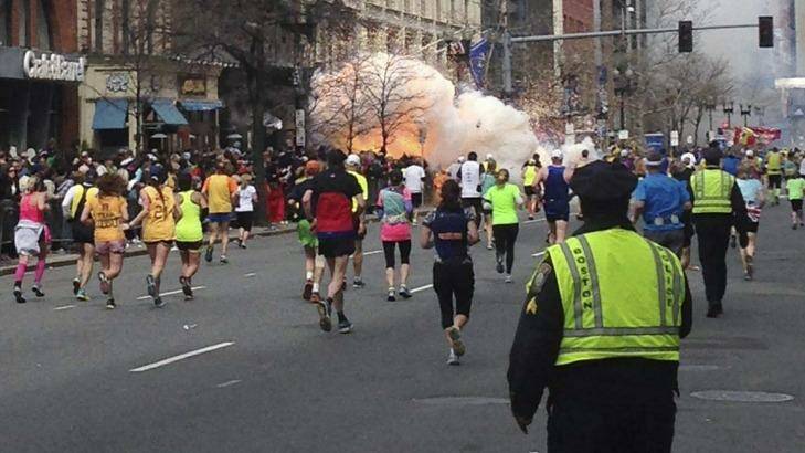Runners continue towards the finish line of the Boston Marathon as a bomb detonates. Photo: Dan Lampariello 