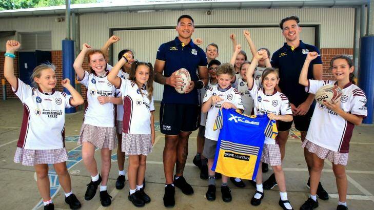 With the kid: John Folau (left) and Clint Gutherson (right) visit Crestwood Public School on Thursday.  Photo: Isabella Lettini