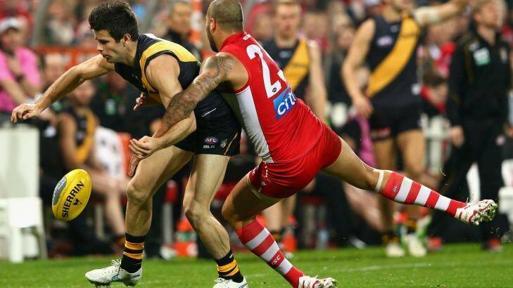 In trouble:  Lance Franklin puts a tackle in on Trent Cotchin. Photo: Cameron Spencer