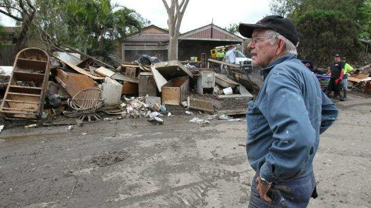 Volunteer truck driver Paul Eadie surveys the rubbish in Brisbane in 2011. Photo: Andy Zakeli