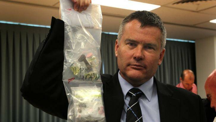 Superintendent Scott Knowles, holds up drugs that were seized during a police raid at Surfers Paradise. Photo: Sahlan Hayes