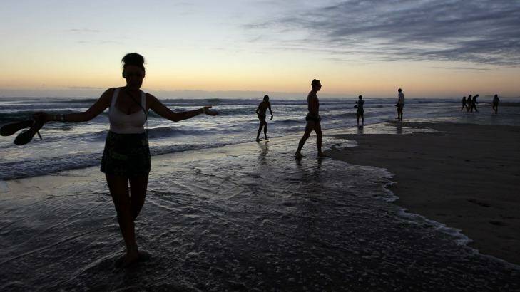Schoolies wait for the sun to rise on the beach at Surfers Paradise. Photo: Sahlan Hayes