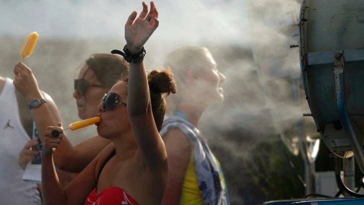 Spectators cool off with popsicles. Photo: JASON REED