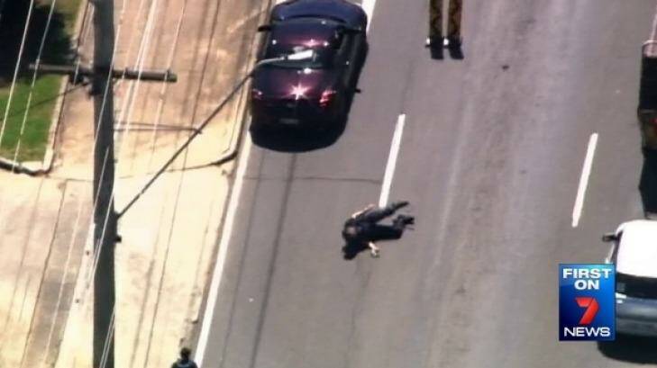 Police officer on the ground near Tygum and Albert Street intersection at Waterford. Photo: Seven News