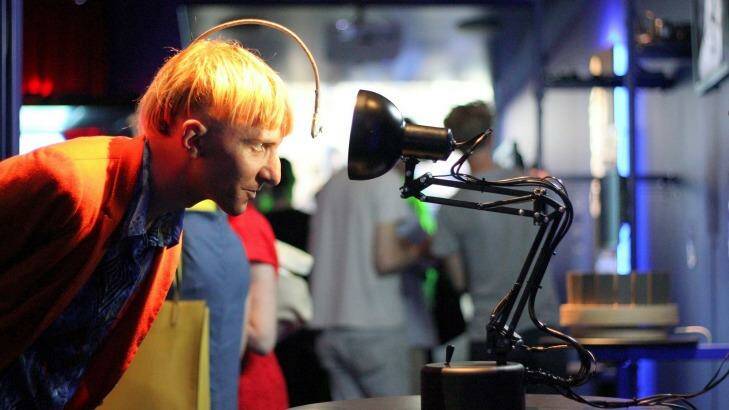Neil Harbisson, the world's first cyborg, with Pinokio, the curious robotic desk lamp that wants to capture your attention. Photo: QUT 