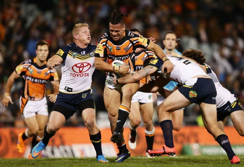 Tight contest: Sauaso Sue of the Wests Tigers tries to burst through the North Queensland defence.