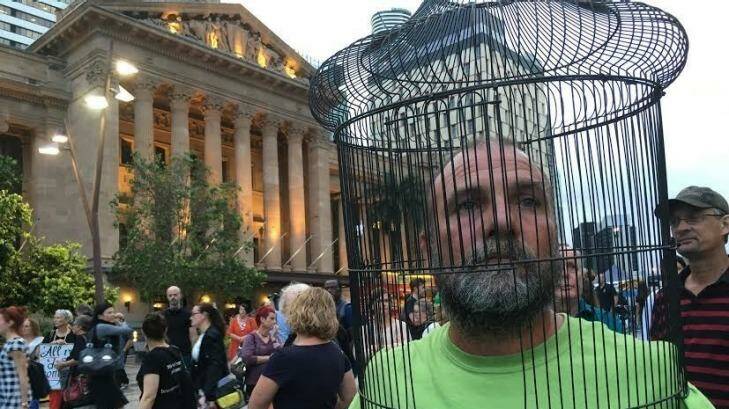 Paul Mansfield wears a cage symbolising the imprisonment of asylum seekers. Photo: Cameron Atfield