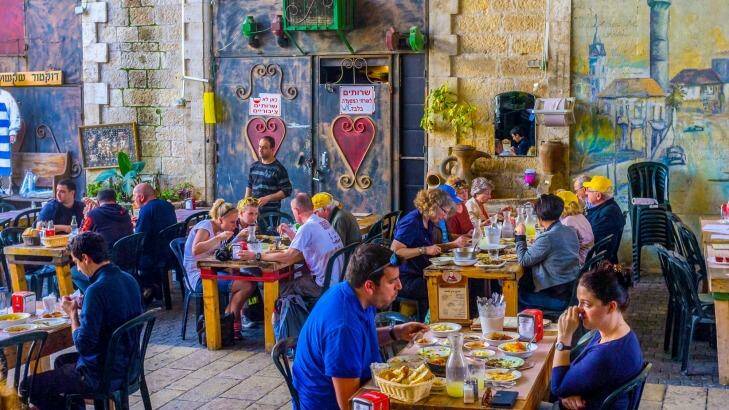 Tourists in one of the Jaffa's cafes eat the famous shakshuka omelet. Photo: iStock