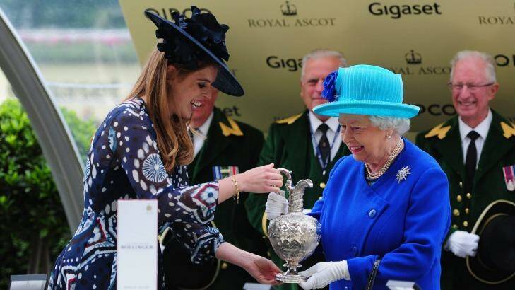Royal day at Royal Ascot: Queen Elizabeth II smiles as she is presented the Hardwicke Stakes trophy by Princess Beatrice after her owned horse Dartmouth wins at Ascot Racecourse. Photo: Harry Trump
