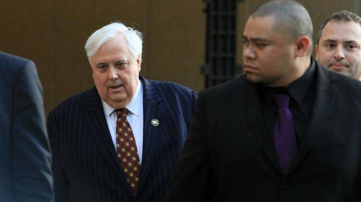 Clive Palmer was flanked by security guards as he left court on Monday. Photo: Jorge Branco