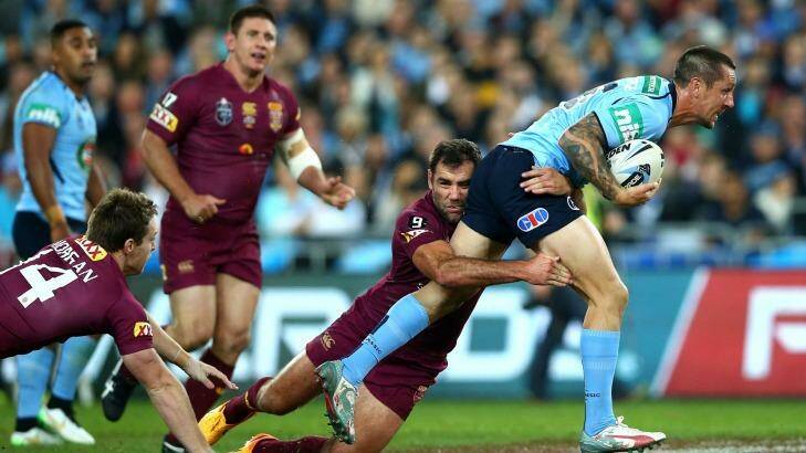 Under pressure: Mitchell Pearce is dragged down by Cam Smith. Photo: Getty Image