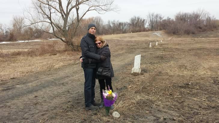 Elaine Joseph with her son on Hart Isalnd. Each white post marks 150 adults or 1000 babies buried. Photo: Andrew Purcell