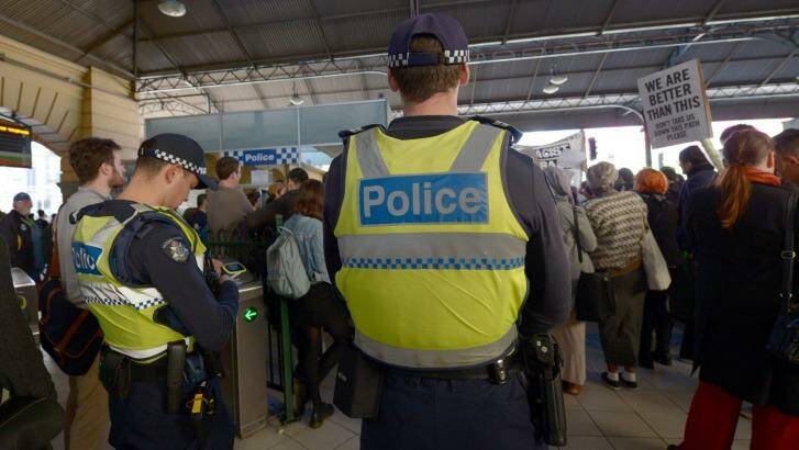 Police watch as protesters rally inside Flinders Street Station on Friday against    Australian Border Force officers taking part in Operation Fortitude. Photo: MAL FAIRCLOUGH