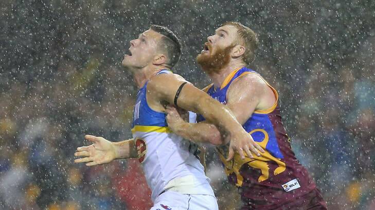 Steven May of the Suns and Daniel Merrett of the Lions feel the full force of the storm in their AFL clash at the Gabba, Photo: Chris Hyde