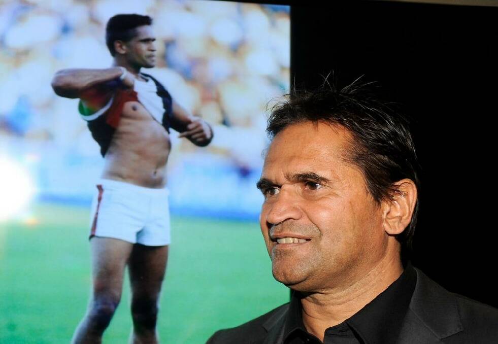 Nicky Winmar at the launch of the AFL Indigenous Round in 2013. In the background is the famous picture of him taking a stand against racism.  Photo: Sebastian Costanzo