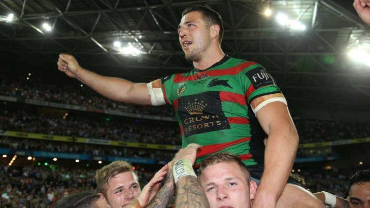 Missed: Rabbitohs enforcer Sam Burgess is chaired off the field by his brothers George and Thomas after the 2015 grand final win over Canterbury. Photo: Brendan Esposito