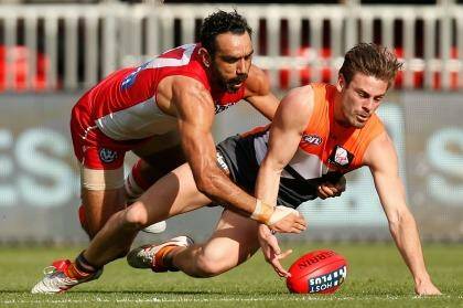 Stephen Coniglio of the Giants and Adam Goodes of the Swans compete for the ball. Photo: Michael Willson/AFL Media
