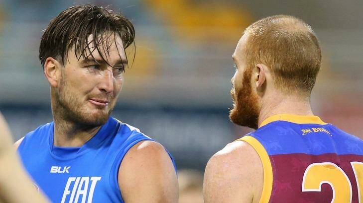 Charlie Dixon of the Suns and Daniel Merrett of the Lions exchange words during the Q-Clash at The Gabba. Photo: Chris Hyde