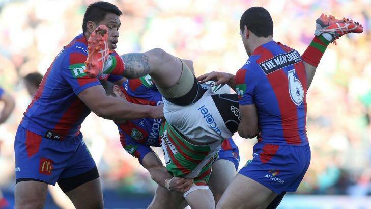 Awkward landing: Aaron Gray of the Rabbitohs is tackled by the Knights defence. Photo: Tony Feder