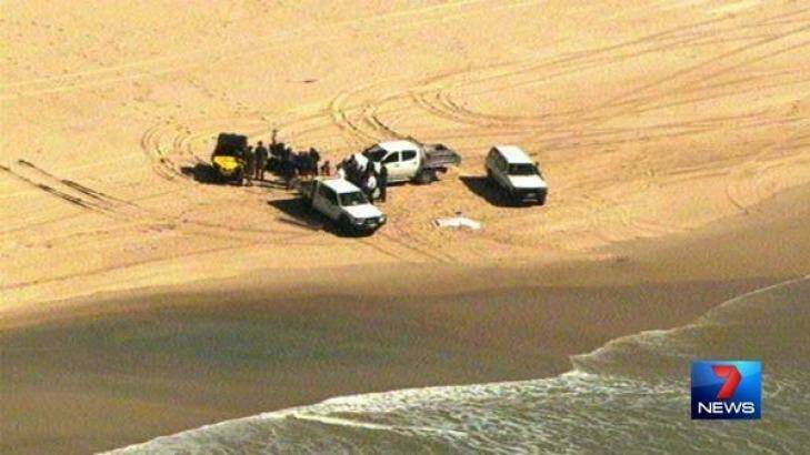 Police at the scene where a man's body washed up on South Stradbroke Island. Photo: Channel Seven/Twitter