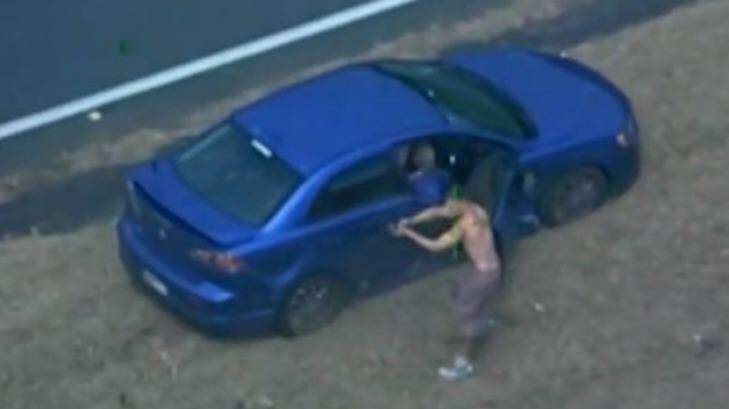 Police release footage of the moment a 154 km car chase ends with the gunmen sprinting towards oncoming traffic with one man firing at a passing car. Photo: Matt M. Duncan