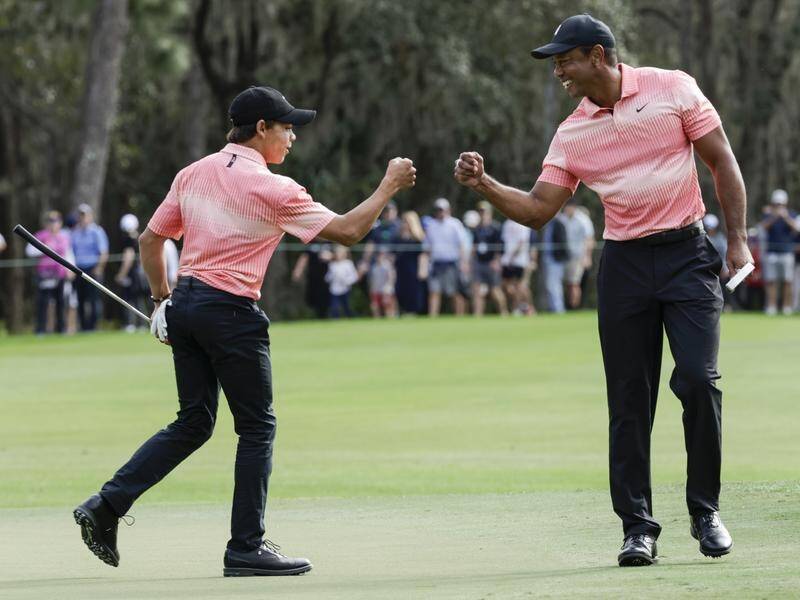Charlie Woods, here bumping fists with dad Tiger, has missed out on his bid to make the US Open. (AP PHOTO)