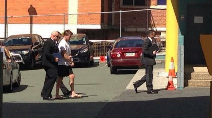 Detectives lead handcuffed Gable Tostee to the watchhouse. Photo: Carrie Greenbank, Nine News
