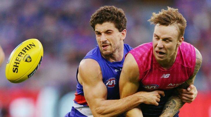 Out of Harmes way: Tom Liberatore tackles Melbourne's rising star James Harmes. Photo: Michael Dodge