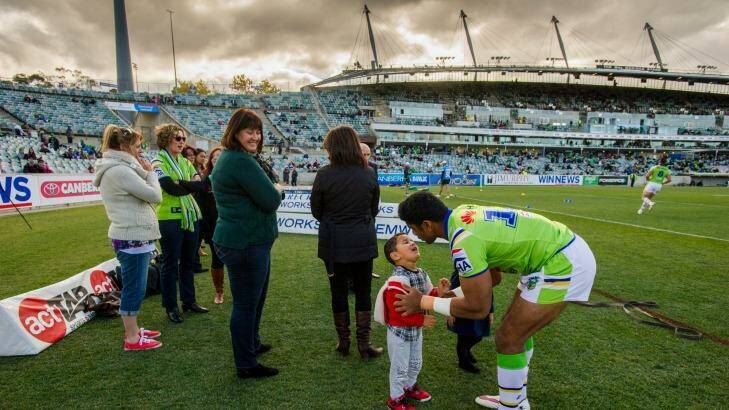 
Canberra Raiders' Sia Soliola gives his son a kiss as the mothers watch on the sideline warm-up.
 Photo: Jay Cronan