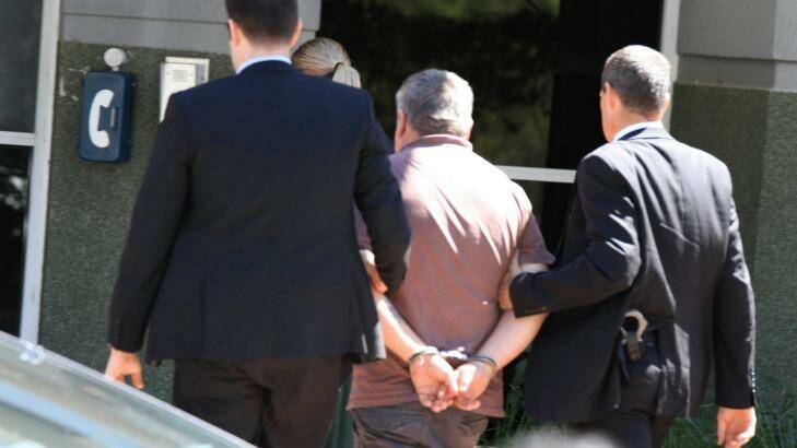 A handcuffed Richard Thorburn is taken into custody. Photo: Jorge Branco