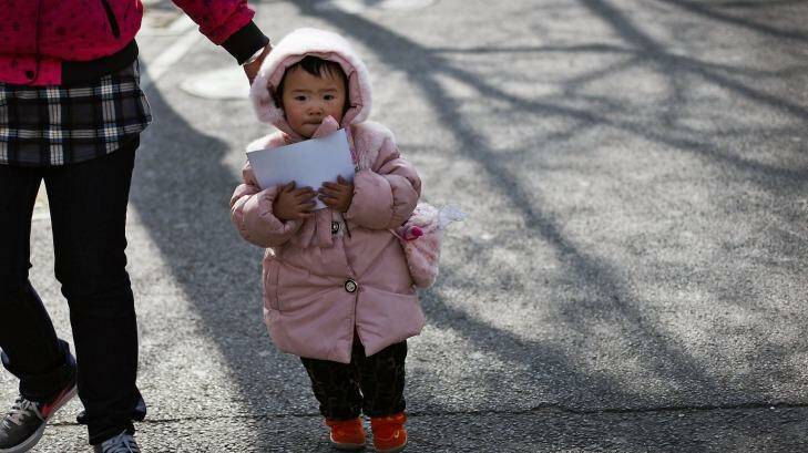 A woman leads a child in Beijing. China's ruling Communist Party announced that it will abolish the country's decades-old one-child policy. Photo: Andy Wong