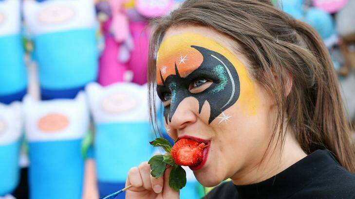 Milli Richards shows exactly how to enjoy a strawberry on a stick at the Ekka.  Photo: Chris Hyde