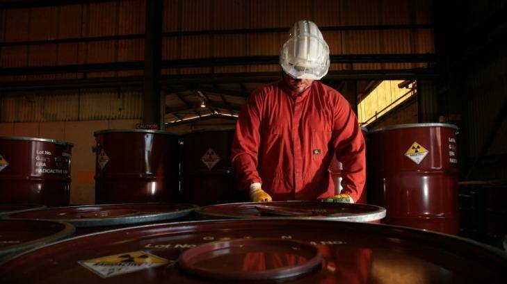 A worker sealing drums of yellow cake. Photo: Glenn Campbell