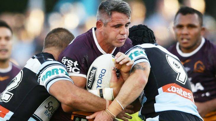 Corey Parker of the Broncos is tackled by the Sharks' defensive line. Photo: Matt King