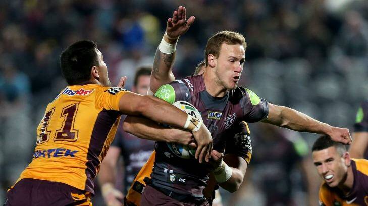 Daly Cherry-Evans of Manly is tackled by the Broncos defence.