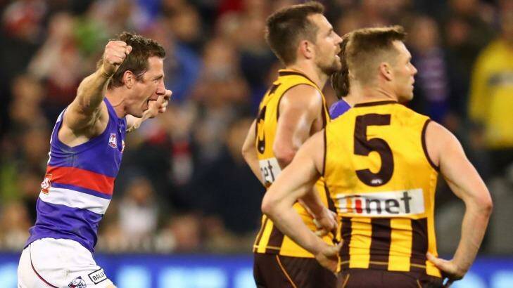 Joel Hamling of the Bulldogs and Dale Morris of the Bulldogs celebrate at the final siren as Sam Mitchell of the Hawks and Luke Hodge of the Hawks look dejected after the second AFL semi-final between Hawthorn Hawks and Western Bulldogs. Photo: Scott Barbour/AFL Media